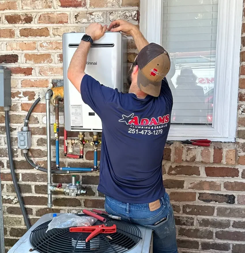 Adams Plumbing & Drain Company installing a tankless water heater in a Travis, AL home