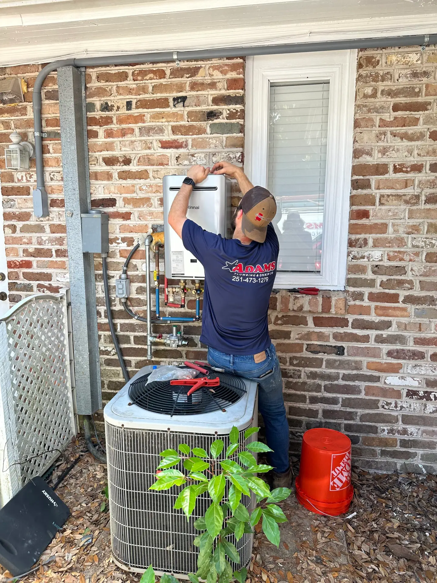 Adams Plumbing & Drain Company installing a tankless water heater in Hillsdale, Mobile, AL