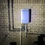 Adams Plumbing & Drain Company installing a tankless water heater in College Park, AL